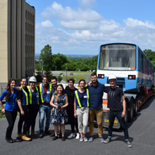 Des membres du comité étudiant Station Polytechnique posent près de la voiture de métro MR-63, peu avant son insertion dans les pavillons Lassonde.