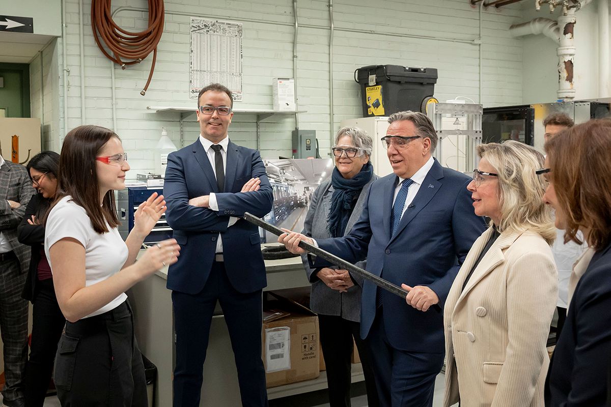 Clara Grandisson Arsenault, étudiante à la maîtrise en génie mécanique, explique des travaux de recherche sur un nouveau moyen de fabrication de matériaux composites au premier ministre François Legault et à des dignitaires. (Photo : Thierry du Bois)