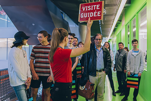 Image - Une étudiante accompagnant des visiteurs lors d'une visite guidée de l'université - Polytchnique Montréal