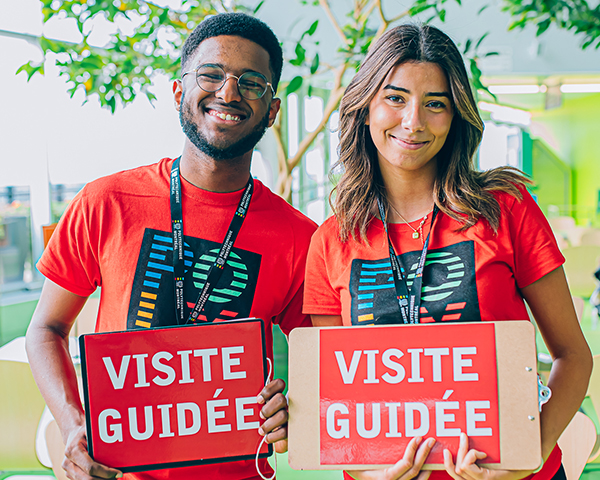 Un étudiant et une étudiante portant un chandail rouge et faisant un sourire - Polytechnique Montréal