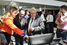 Caroline Boudoux, professeure agrégée au Département de génie physique de Polytechnique Montréal (gauche), Carl-Éric Aubin, professeur titulaire au Département de génie mécanique de Polytechnique Montréal et directeur exécutif et scientifique de l’Institut TransMedTech (centre) et Gaétan Barrette, ministre de la Santé et des Services sociaux du Québec (droite),  visitant un kiosque lors de l'inauguration de l'Institut TransMedTech au CHU Sainte-Justine, le 24 avril 2017.